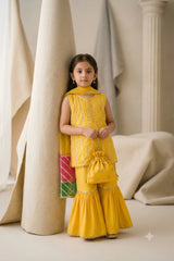 Young girl wearing a bright mustard yellow katan silk sleeveless gota kurti and flared gharara set with contrast border dupatta and matching potli bag.