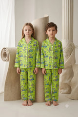Twin girl and boy standing side by side wearing matching vibrant lime green linen button-down pajama sets with colorful dream and rainbow prints.